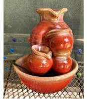 A ceramic fountain with flowing water in the shape of a pitcher and bowls.