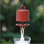 A red kitchen tool pouring white liquid into a glass.