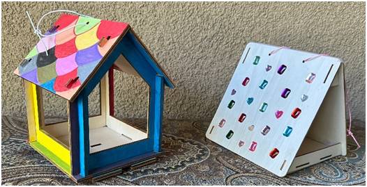 A colorful birdhouse and a white board with colorful magnets.