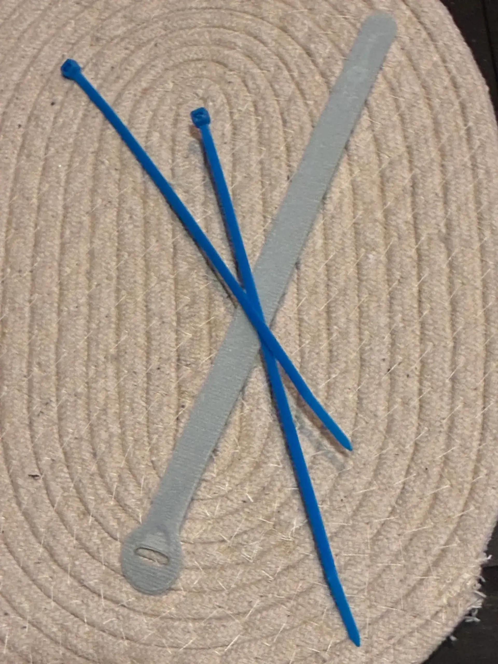Two blue zip ties and gray strap